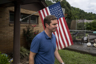 In Whitesburg, Kentucky, Gov. Andy Beshear visits a house with flood damage in July 2022. Beshear was criticized after the flood for public comments that made him appear to not understand that fossil fuel emissions were making storms more potent, but his comments also conveyed a sense of empathy and compassion. “I wish I could tell you why we keep getting hit here in Kentucky,” the governor said at the time. Credit: Michael Swensen/Getty Images.