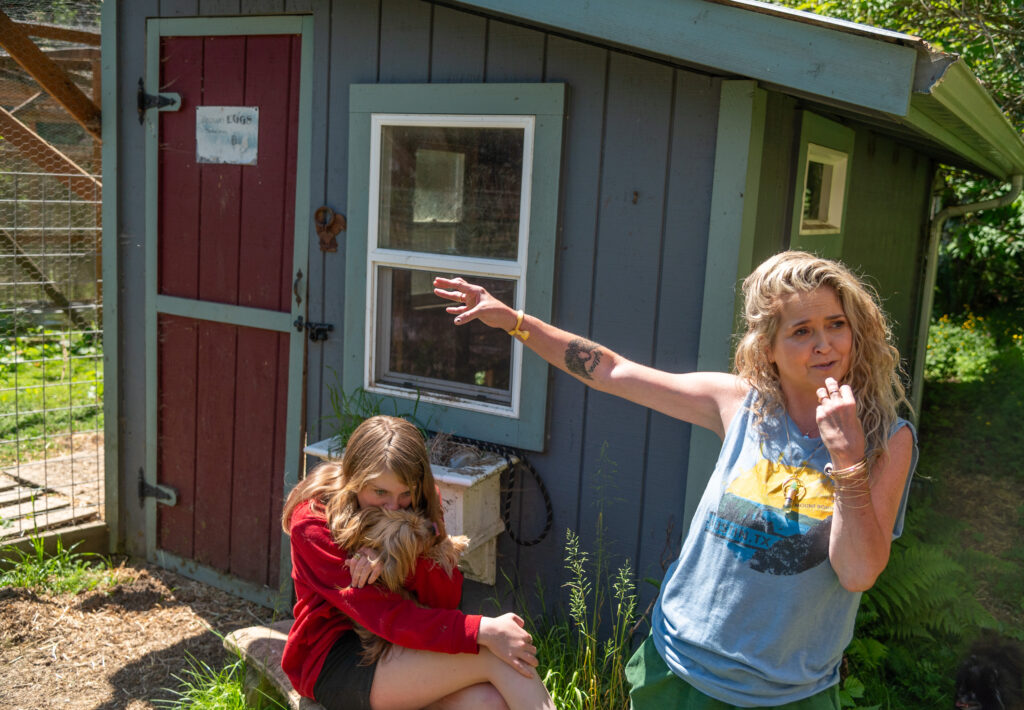 Kim Frey, right, describes how a cougar got into her family's chicken house, as her daughter, Haddie, 12, holds a dog that is just one of many animals the family keeps at their home in the woods west of Port Angeles, on Washington's Olympic Penninsula. Credit: Michael Kodas