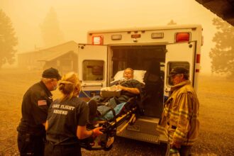 Don Crail, whose home burned down in the Dixie Fire, is rushed into an ambulance for a medical issue in Greenville, California in August 2021. Credit: Josh Edelson/AFP via Getty Images.