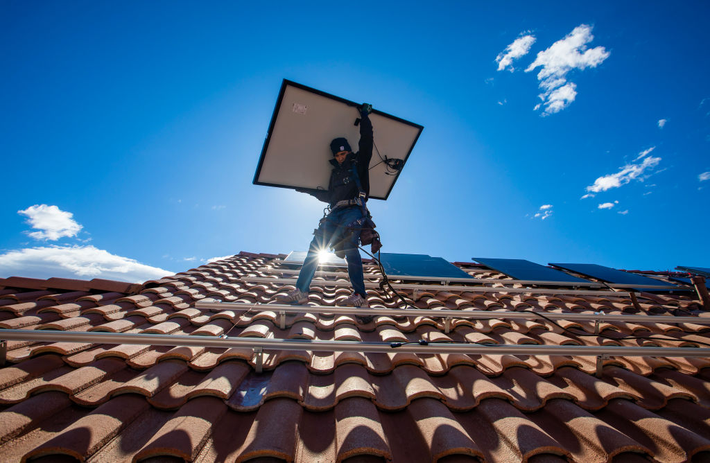 Employees of Sunrun, nation's largest rooftop solar installer, carry panels into position in North Las Vegas, Nevada.