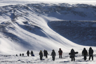 People hike near Thule Air Base on March 25, 2017 in Pituffik, Greenland. Credit: Mario Tama/Getty Images)