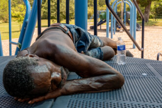 A person rests in the shade on a playground set in the Hungry Hill neighborhood on June 20, 2023 in Austin, Texas. Extreme temperatures across the state have prompted the National Weather Service to issue excessive heat warnings and heat advisories that affect more than 40 million people. Credit: Brandon Bell/Getty Images