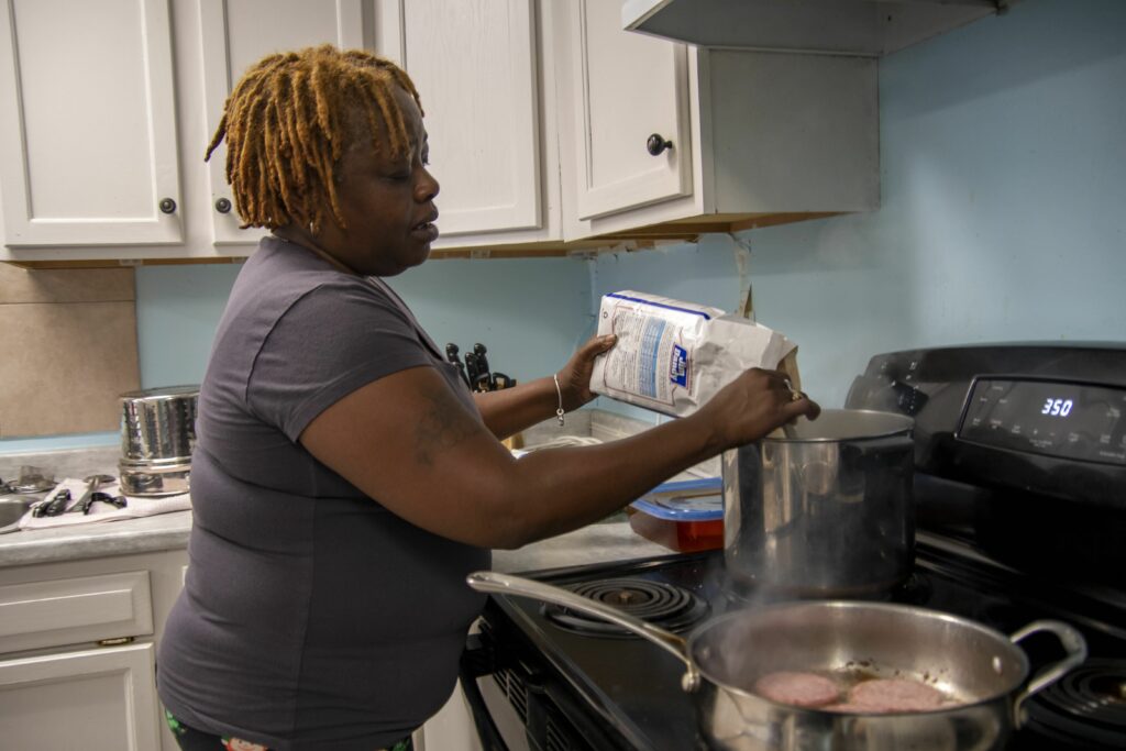Betty Catlin prepares breakfast for her neighbors at Light of the Village ministry.  Credit: Lee Hedgepeth/Inside Climate News. 