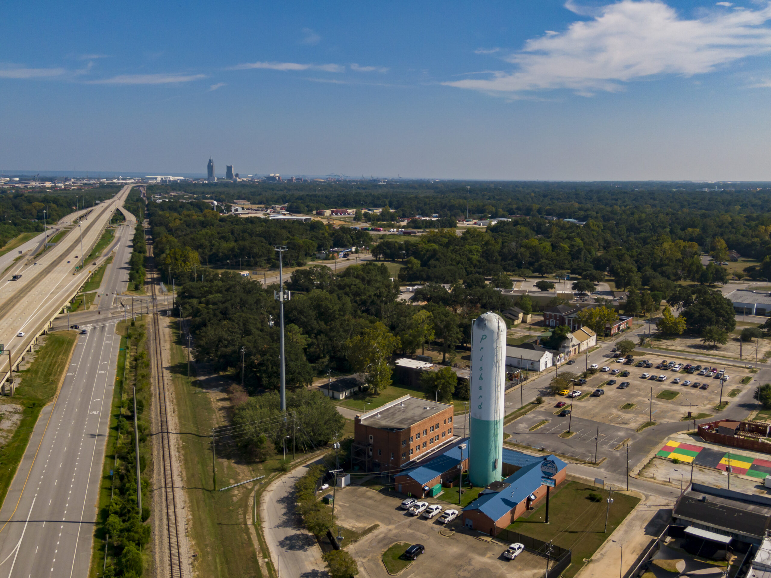 A water tower in Prichard, Alabama, a majority Black town with a crumbling water infrastructure. Mobile’s nearby skyline is visible in the background. Credit: Lee Hedgepeth/Inside Climate News